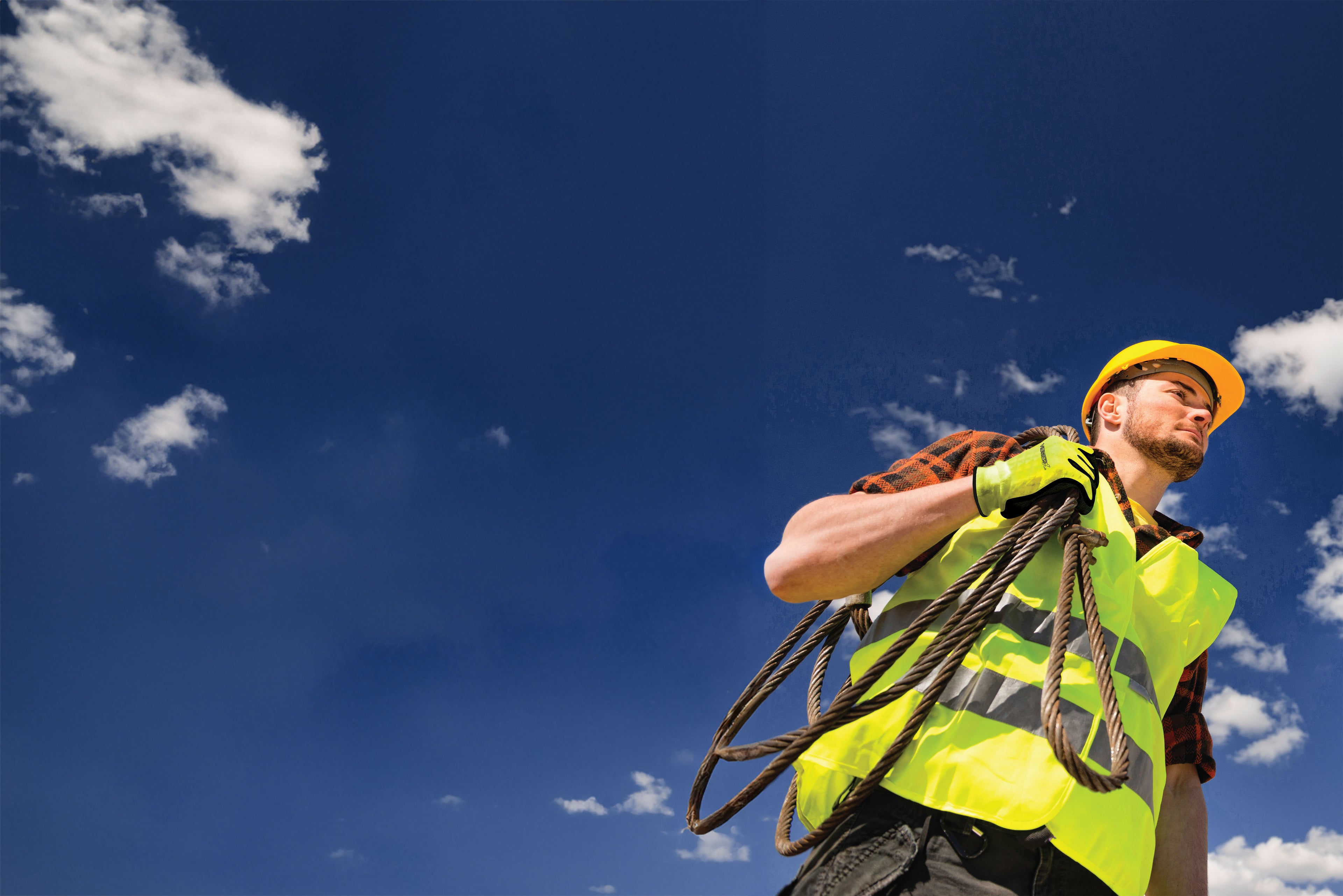 Man carrying a rope while wearing VisWERX gloves and vest.